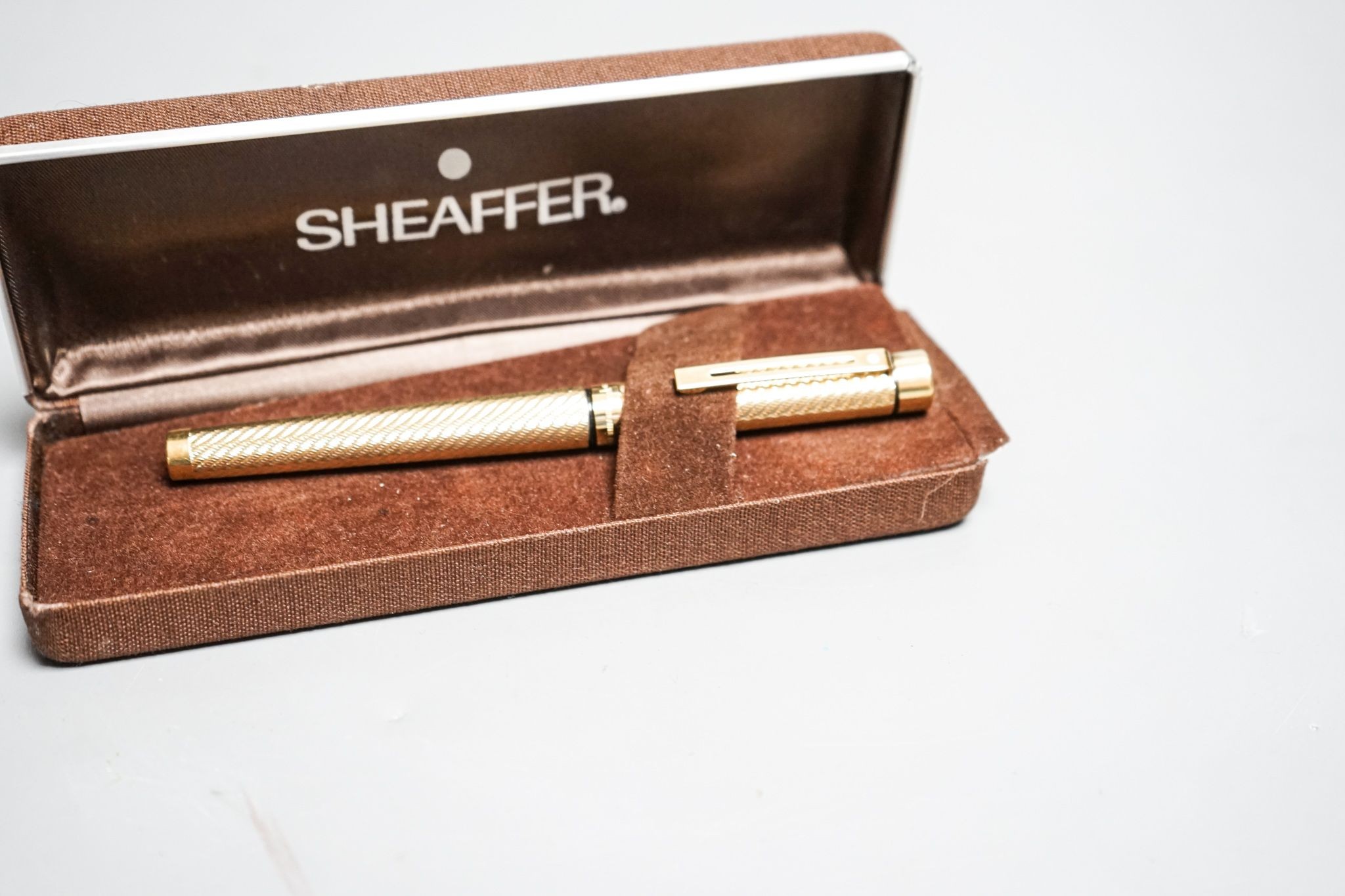 A cased gold plated Shaeffer fountain pen.